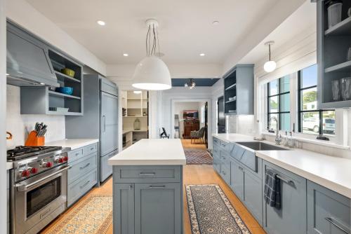 a kitchen with blue cabinets and white counter tops at Coastal La Jolla Luxury - AC & Large Ocean View Patio! in San Diego