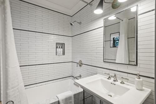 een witte badkamer met een wastafel en een spiegel bij Coastal La Jolla Luxury - AC & Large Ocean View Patio! in San Diego