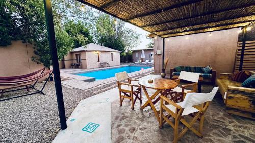 a patio with a table and chairs and a pool at Ickota B&B in San Pedro de Atacama