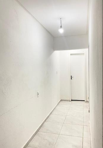 una habitación vacía con una pared blanca y una puerta en Casa em Balneário Camboriú, en Camboriú