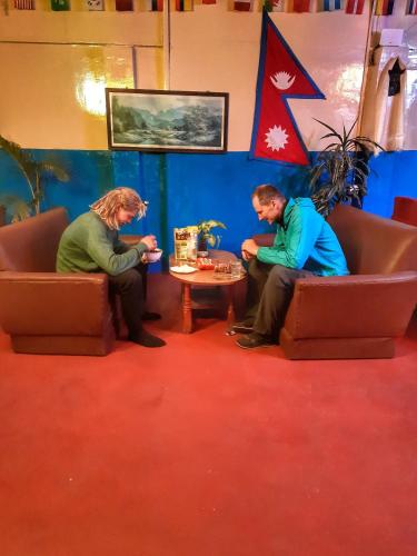 two people sitting on chairs in a room at Best Hostel in Kathmandu