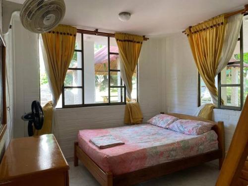 1 dormitorio con 1 cama en una habitación con ventanas en Casa Finca Anapoima, en Anapoima