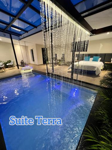 a swimming pool with a waterfall in a hotel room at Springhills Quito Airport in Tababela