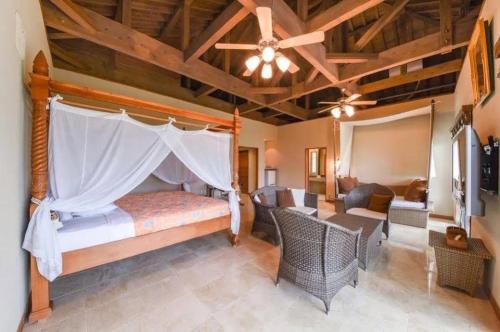 a bedroom with a bed and chairs and a ceiling at エコヴィレッジ西表 Eco Village Iriomote in Iriomote