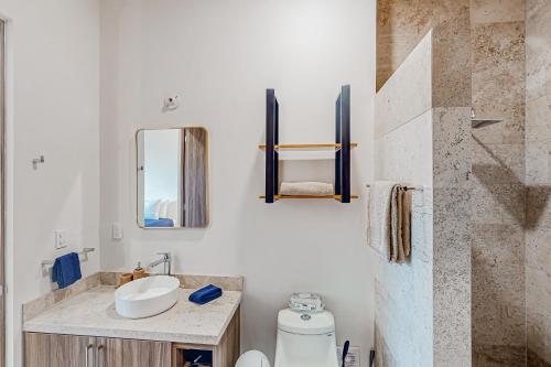 uma casa de banho com um lavatório, um WC e um espelho. em Torres San Jose C25 em San José del Cabo