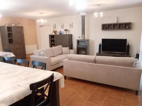 a living room with two couches and a television at Gîte éco-responsable avec jardin, internet, chambres équipées et adaptés PMR - FR-1-489-484 in Mesples