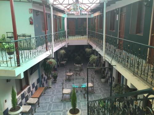 une cour intérieure d'un bâtiment avec des chaises et des plantes dans l'établissement HOSTAL FAMILIAR FG, à Cochabamba