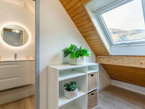 une salle de bains avec une lucarne et deux plantes dans l'établissement Duplex T2 rénové pour 4 personnes à Vielle-Aure avec parking privé et navette gratuite - FR-1-296-487, à Vielle-Aure