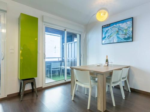 une salle à manger avec une table et un mur vert dans l'établissement Appartement 8 pers. à Peyragudes - Pieds des pistes, balcons, 4 chambres, options confort - FR-1-695-45, à Germ