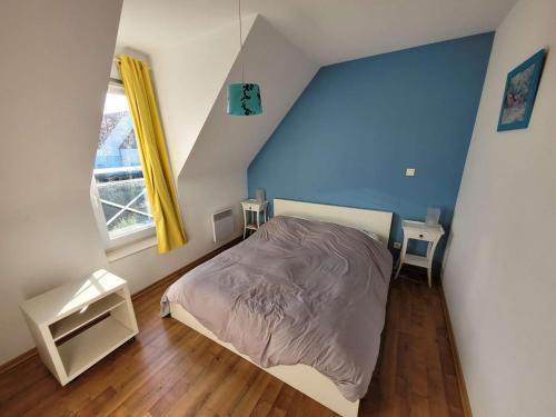 - une chambre avec un lit et un mur bleu dans l'établissement Villa Wimereux, 4 pièces, 6 personnes - FR-1-675-33, à Wimereux