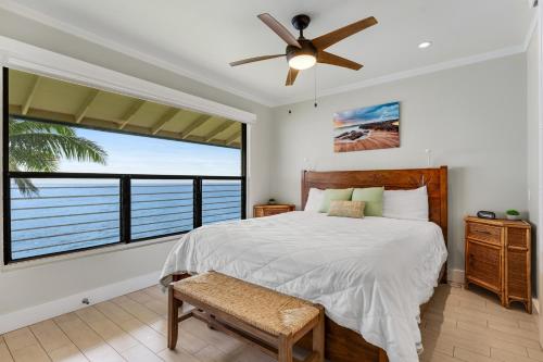 een slaapkamer met een bed en een groot raam bij Poipu Shores 403A in Koloa