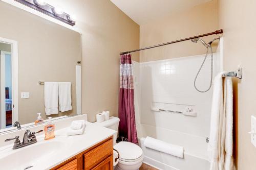a bathroom with a sink and a toilet and a mirror at Poolside Tranquility in Queen Creek