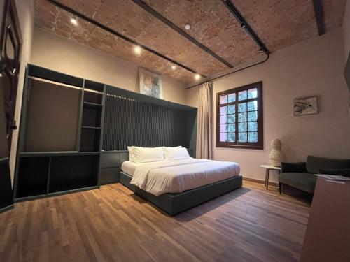 a bedroom with a bed and a couch and a window at Casa Maka in San Luis Potosí