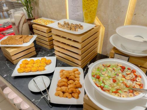 a buffet with plates of food on a table at The Art Nest Hotel Nha Trang in Nha Trang