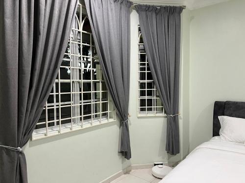 1 dormitorio con cortinas grises, 1 cama y ventana en Mutiara Villa Homestay - Comfort Away From Home en Merlimau