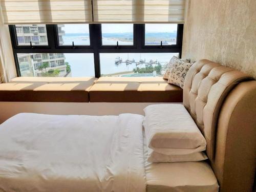 uma cama e um sofá num quarto com uma janela em JB Country Garden Danga Bay@J Agape Homestay 0503 em Johor Bahru