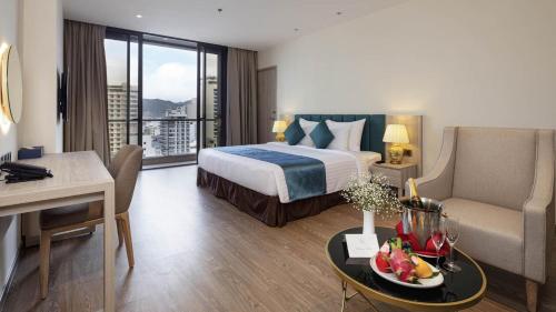 um quarto de hotel com uma cama, um sofá e uma mesa em Art Nest Hotel Nha Trang em Nha Trang