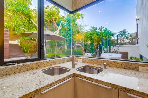 a kitchen with a sink and a large window at Sunset Cliffs Modern Luxury Estate w Ocean Views, Oversized Spa, AC, Yard! in San Diego