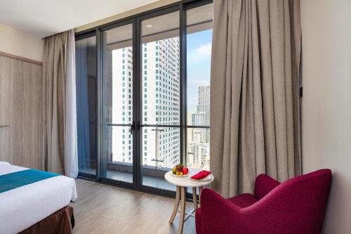 a hotel room with a bed and a large window at The Art Nest Hotel Nha Trang in Nha Trang