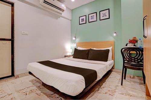 una camera con un letto, una sedia e un tavolo di Collection O Dsp Hotels a Ghansoli
