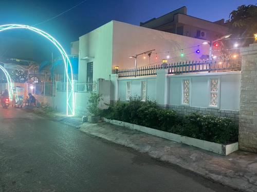 a white house with lights on a street at night at Villa sân vườn Misa in Phan Thiet