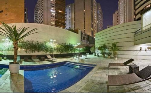 a swimming pool in the middle of a city at night at Studio Living Quality Jardins in Sao Paulo