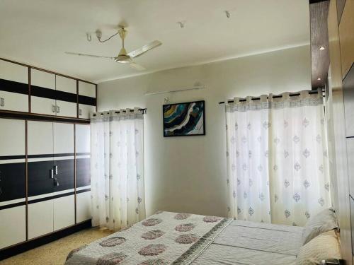een slaapkamer met witte gordijnen, een bed en een plafond bij Stay @ Race Course Road, BLR in Bangalore