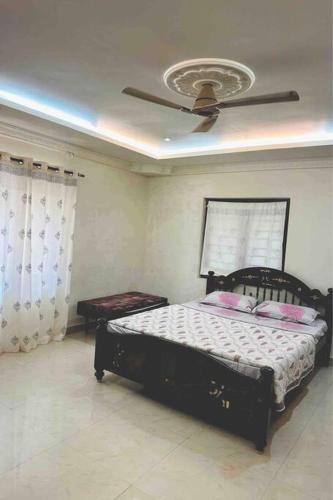 een slaapkamer met een bed en een plafondventilator bij Stay @ Race Course Road, BLR in Bangalore