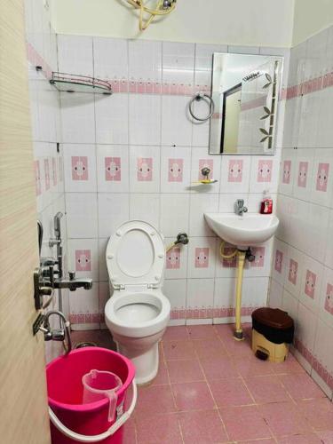 een roze en witte badkamer met toilet en wastafel bij Stay @ Race Course Road, BLR in Bangalore