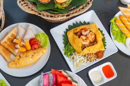 een tafel met borden met voedsel op borden bij Dong Talay Lipe Beach Resort in Ko Lipe