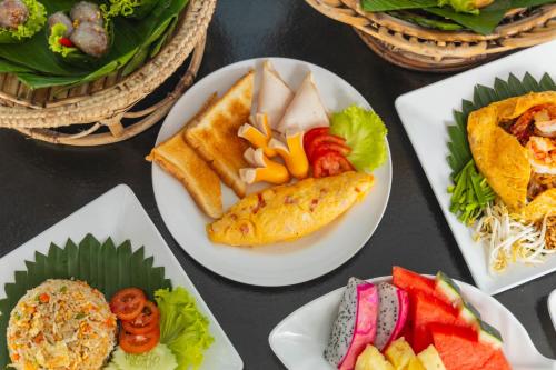 een tafel met borden en manden met voedsel bij Dong Talay Lipe Beach Resort in Ko Lipe