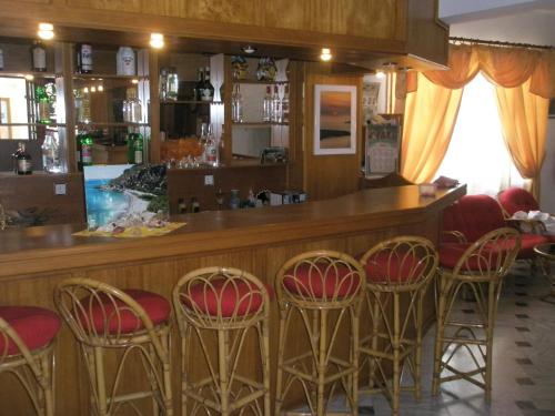 a bar with red chairs in a restaurant at Ostria in Agia Galini