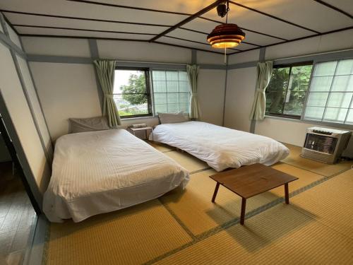 een slaapkamer met 2 bedden en een tafel en ramen bij Otaru - House - Vacation STAY 15278 in Otaru
