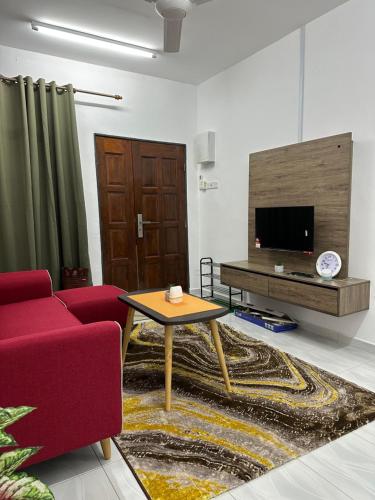 ein Wohnzimmer mit einem roten Sofa und einem TV in der Unterkunft Paddy View Homestay Kangar in Kangar