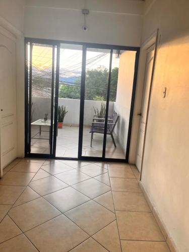 een lege kamer met een deur naar een patio bij Apartamentos Trebol in Comayagua