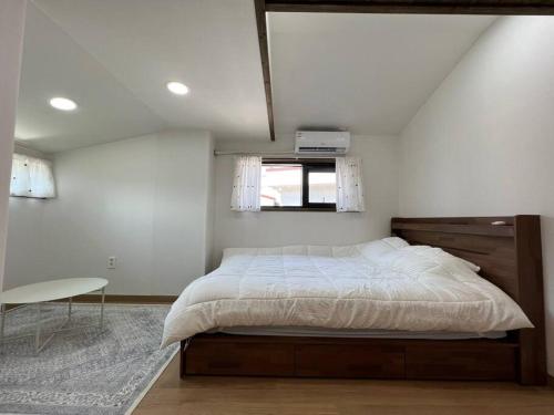 a bedroom with a large bed and a window at An Gimnyeong Stay in Jeju