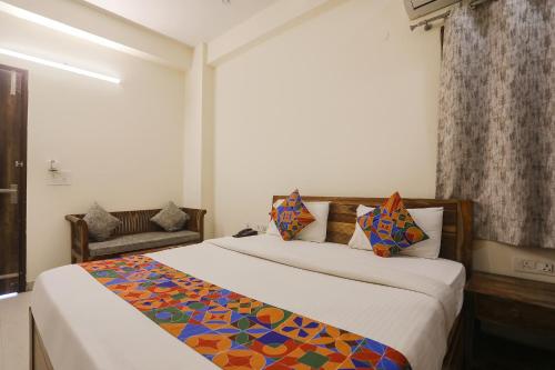 een slaapkamer met een groot bed en een kleurrijke deken bij FabHotel The Avasa in Noida