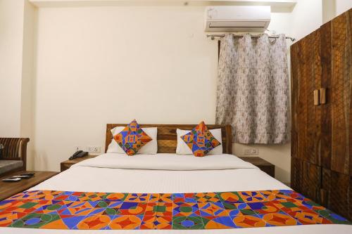 een slaapkamer met een bed met een kleurrijke quilt bij FabHotel The Avasa in Noida