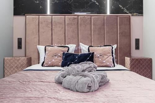 ein Bett mit einem großen Kopfteil mit Handtüchern darauf in der Unterkunft Family Residence Boutique Apartments in Lwiw