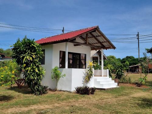 une petite maison blanche avec un toit rouge dans l'établissement TK Beach Resort Koh Mak, à Ko Mak