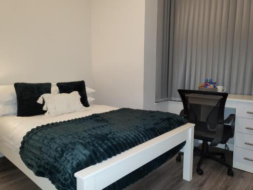 a bedroom with a bed and a desk and a chair at Spacious Rooms - Suitable for Contractors Relocators Business Travellers Long Stay Discounts in Parkside