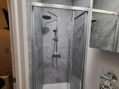 a shower with a glass door in a bathroom at Spacious Rooms - Ideal for Contractors Relocators Business Travellers Long Stay Discounts in Parkside
