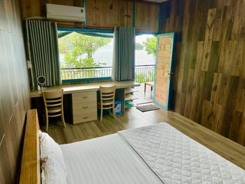 a bedroom with a bed and a desk and a window at Bến Hồ Homestay in Xã Gia Tân