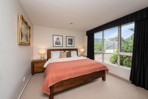 ein Schlafzimmer mit einem Bett und einem großen Fenster in der Unterkunft Yera Lodge Coastal Homestead in Rye Spa/Tennis Crt in Rye