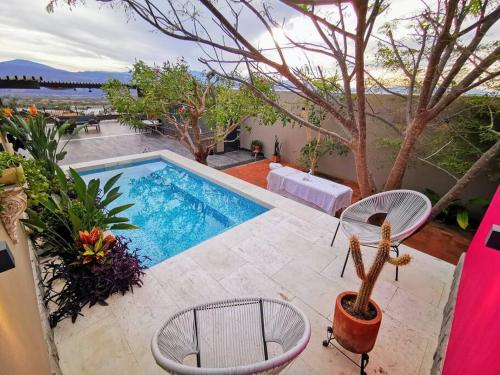 einen Pool mit zwei Stühlen und einem Kaktus in der Unterkunft Casa de campo con vista al atardecer y alberca in Estancia los López