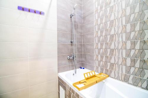 een badkamer met een bad, een douche en een bad bij AB Apart Business 35237 in Astana