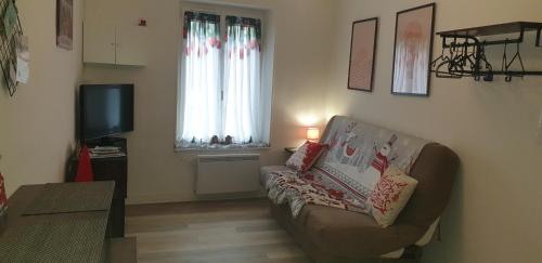 a living room with a couch and a tv at Studio meublé et équipé in Ingré