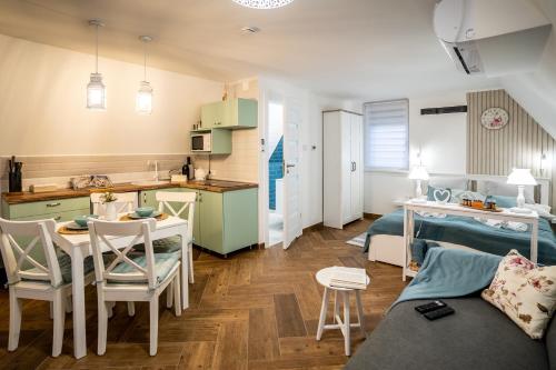 a small kitchen and a living room with a table and chairs at Szanna Apartman in Doboz