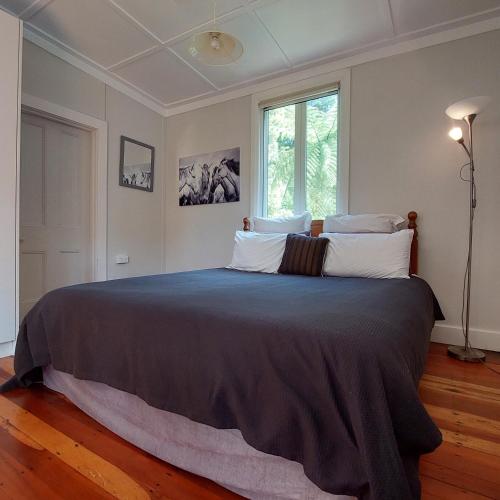 a large bed in a bedroom with a window at Morere Cottage Accommodation in Morere