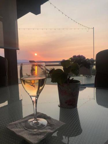 a glass of wine sitting on a table with a vase at Romantic Spacious Suite with Salish Sea & Mountain Views at Seattle Luxury Estate in Seattle